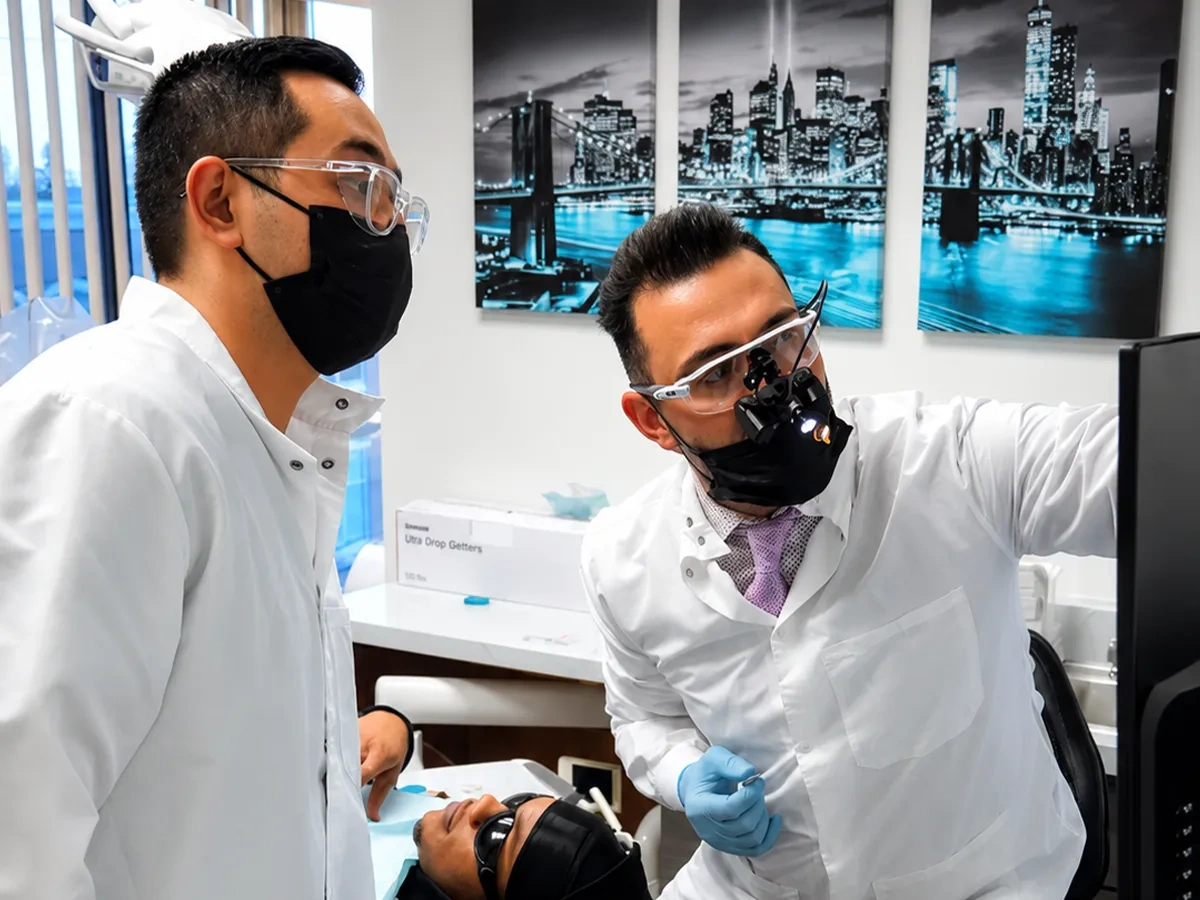 A patient admiring their smile in the mirror at Delicate Smiles